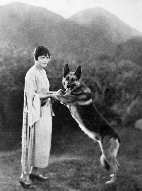 Woman and dog Bothe standing on 2 legs.. Actress and German Shepherd dog star Strongheart. 1923, Photo Play (USPD. pub date, artist life/Commons.wikimedia.org)