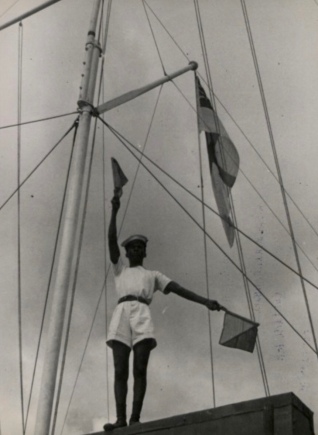 Man on boat.Flag Signals by sailor among boat shrouds. The National Archives UK (PD/Commons.wikimedia.org)